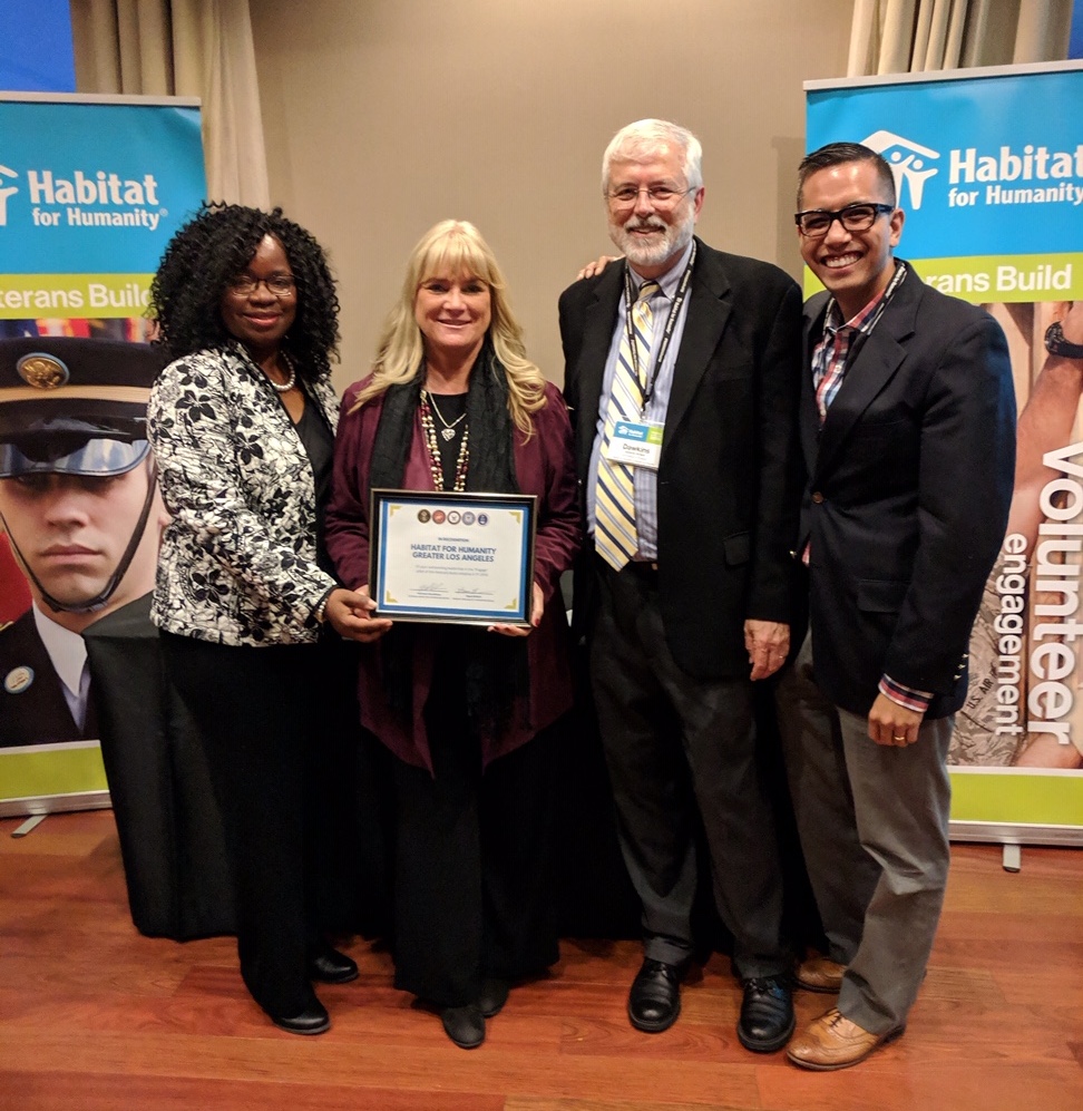 Four Habitat LA staff members with the Engagement Award smiling.