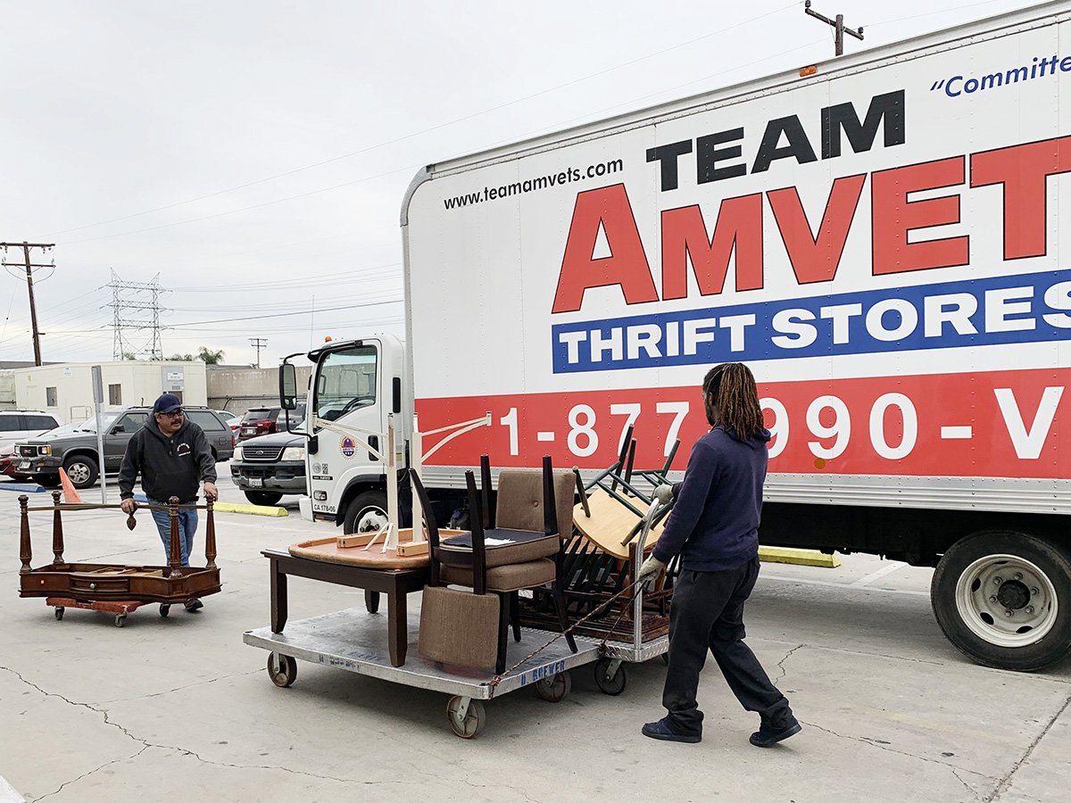 Habitat LA ReStore volunteers carrying chairs and tables to a moving truck.