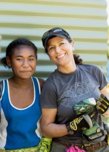 Michelle Meghrouni smiling with a younger girl as she volunteers on site.